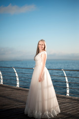 happy bride in a wedding dress,wedding outfit bride,young duffel is spinning in a wedding dress on a background of the sea,morning wedding photo shoot of the bride,bride portrait