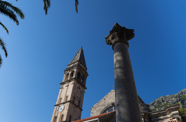Fototapeta na wymiar Perast. The Catholic Church and the Roman column against the sky. Montenegro.