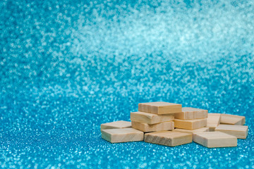 Fototapeta na wymiar Empty pile of wooden letters on the surface of a blue background, selective focus
