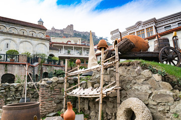 Tbilisi street. National Georgian flavor. Pitchers, millstones, arba, wine barrels. Georgia.