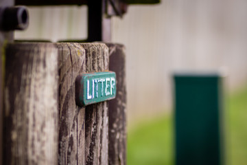 Old Wooden Trash Container with Litter Sign Attached
