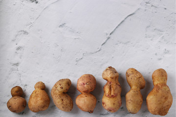 Ugly organic abnormal potatoes on marble background, Concept organic vegetables