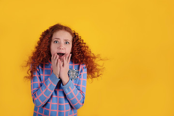 Beautiful red-haired girl on a yellow background