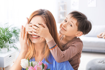 Little boy greeting his mother at home