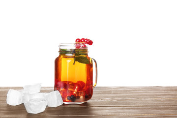 Mason jar of cold tea on table against white background
