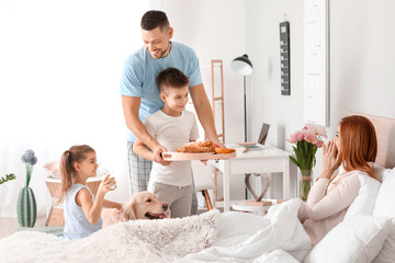Happy husband with children bringing his wife breakfast in bed - obrazy, fototapety, plakaty