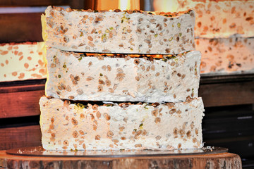 Home made artisan assorted nougat in different flavors. Delicious traditional festive torrone o nougat with nuts, pistachios or almonds. Selective focus.