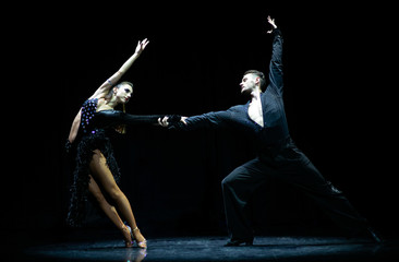 Couple of dancers performing on isolated black background