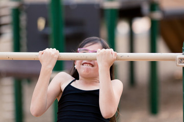 Sisters are playing and using teamwork at the playground.