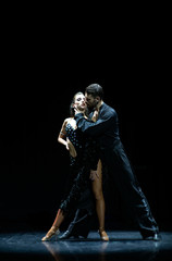 Couple of dancers performing on isolated black background