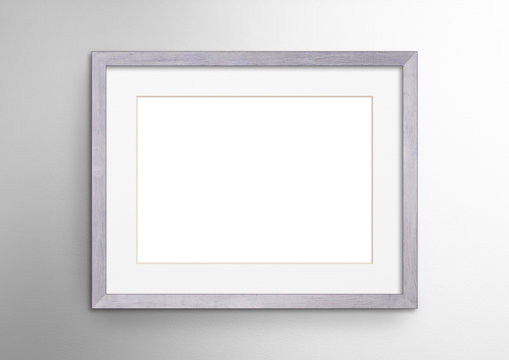 Empty frame. Blank light grey mounted landscape frame on white wall