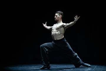 male muscular ballroom dancer making pose isolated on black