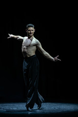 Fototapeta na wymiar male muscular ballroom dancer making pose isolated on black
