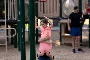Obraz premium Sisters are playing and using teamwork at the playground.