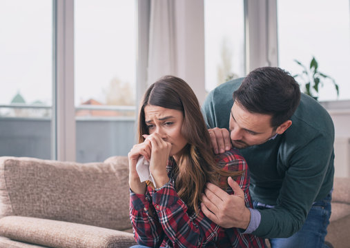 Boyfriend consoling crying girl at home