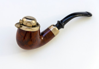 A vintage wood and metal pipe with its cover closed