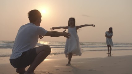 Happy family father and daugther hug and kiss each together on beach and sea with sun flare in evening. Family, Freedom, Relationship, embrace and Travel concept. Positive emotion and feeling warm.