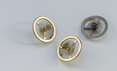 A closeup pic of three Spiral watch springs for mechanical watches on a white background