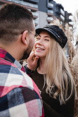 Loving couple kissing outdoor. Cute couple of hipsters is walking in spring park. Beautiful sunny day. Walking on the city's street, spring evening. Honeymoon concept.