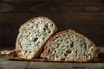 Bread, traditional sourdough bread cut into slices on a rustic wooden background. Concept of traditional leavened bread baking methods. Healthy food.