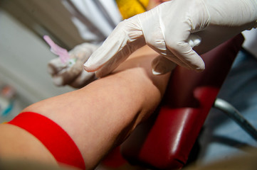 Nurse taking blood sample from patient at the doctors office