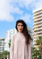 Lonely and sad young woman looking at infinity on the beach on a winter morning