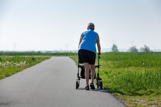An older woman with a walker to help her to walk outside in nature. Leiderdorp the Netherlands.