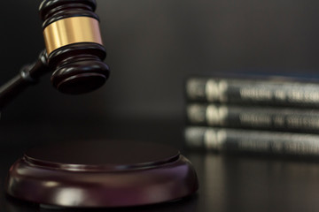 Judge's gavel hitting block with books on the background