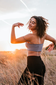 Black Skinned Afro Girl Dancing With The Beach In The Background, Vertical Image