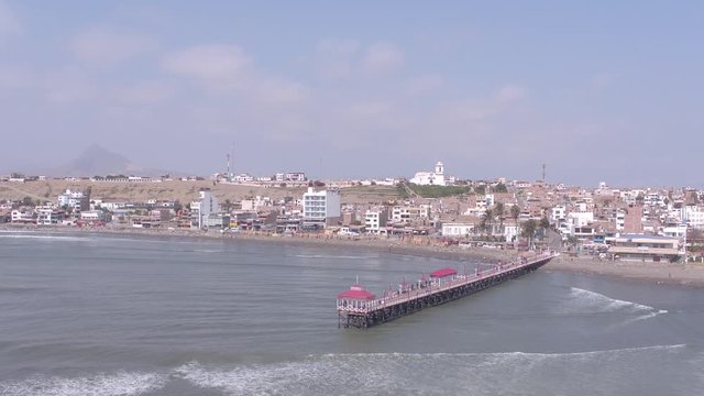 Left traveling aerial drone view move of Huanchaco Beach in Trujillo city at a sunny day in La Libertad Region, Peru
