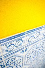 Bright yellow wall copy space framed by delicate blue and white Portuguese azulejo tiles