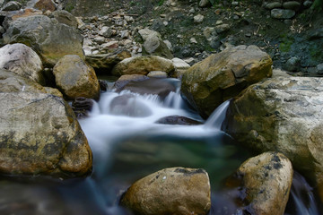 Naklejka na ściany i meble Long time exposure shot of a creek and rocks