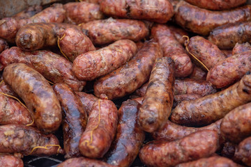 A grill full of coocked chorizos or sausages ready to eat a choripan