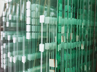 Standing in a warehouse in a stack of thick silicate chrome greenish glasses with a white rectangular print.