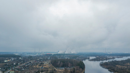 Obraz premium Aerial landscape with vilage and river on smokestacks and pollution from industrial paper mill background. Ecological problem concept.