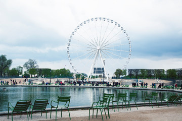 Paris touristic square with garden, sculpture and big ferris wheel on cloudy sky