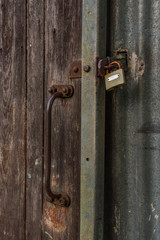 A wooden barn door closed with a padlock