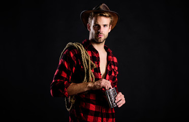 Western culture. Man wearing hat hold rope and flask. Lasso tool of American cowboy. Man handsome...