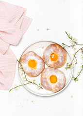 Homemade sweet easter buns with apricot and powdered sugar for breakfast. Top view. Copy space.