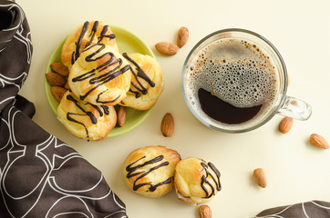 top view on coffee and cake. cappuccino and profiteroles with chocolate icing and almonds closeup..