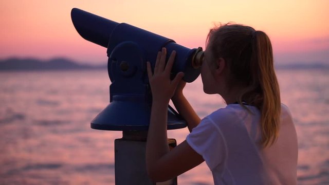 A Young Girl Looking At The Dramatic Sky With Her Telescope - Medium Shot