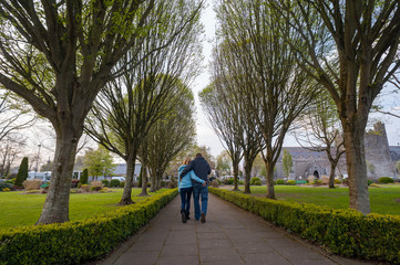 Couple walking through park in the town of Adare in county Limrick, Ireland