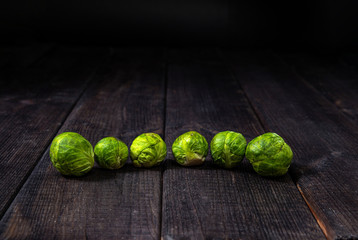 Brussels sprouts on a dark wooden background. The concept of food and cooking. Eating vegetables and healthy nutrition. Eating Brussels sprouts, adding to dishes.