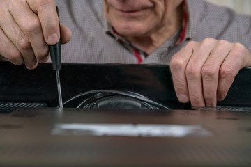 senior citizen wrinkled hand unscrews outdated television detail repairing set at home