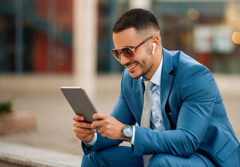 Obraz na płótnie Canvas Attractive young businessman using digital tablet