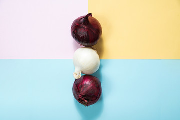 Red onion and white onion on a pastel background. The concept of food and cooking. Eating vegetables and healthy nutrition. Eating red onions, adding to dishes.