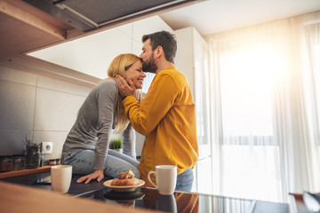 Young couple relaxing at home with cup of coffee