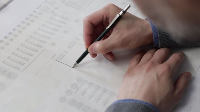 Architect drawing a plan on tracing paper