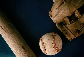 Baseball equipment flat lay with old used ball and brown wooden bat and players glove, copy space...