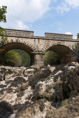 Fototapeta na wymiar Old stone bridge and dry riverbed in hot summer. Knin in Croatia.